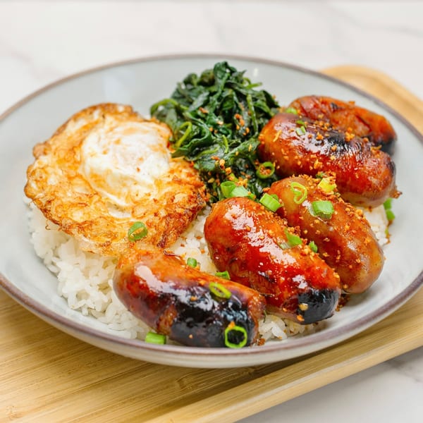 Take Ur Seat's brunch plate with grilled sausages, fried egg, rice, and greens.