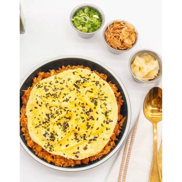 Take Ur Seat's kimchi fried rice with a fluffy omelet, garnished with seaweed, scallions, and fried onions.